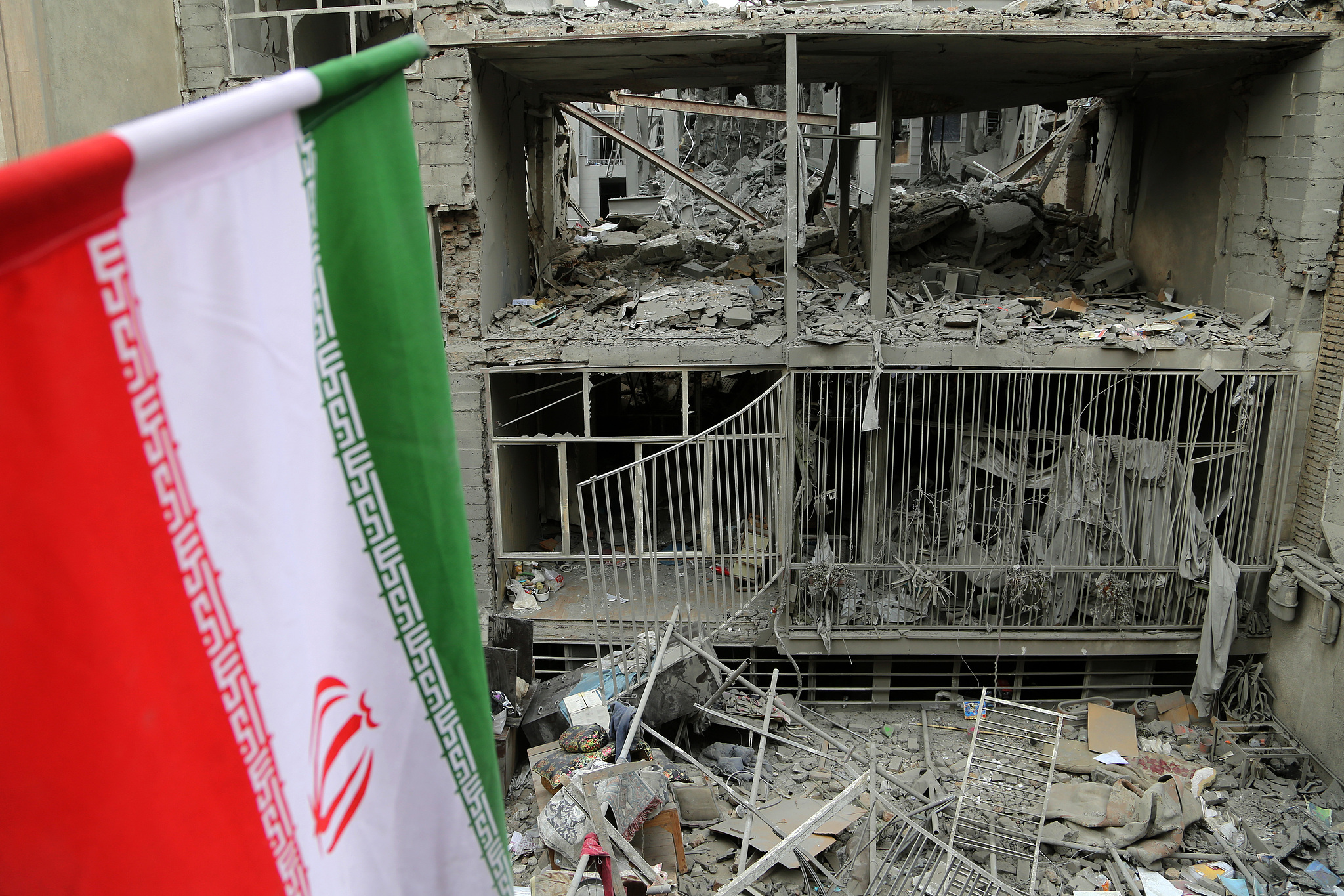 An Iranian flag amid major destruction in the Javadiyeh and Beryanak districts as a result of US-Israeli attacks in Tehran, Iran on March 15, 2026. /VCG