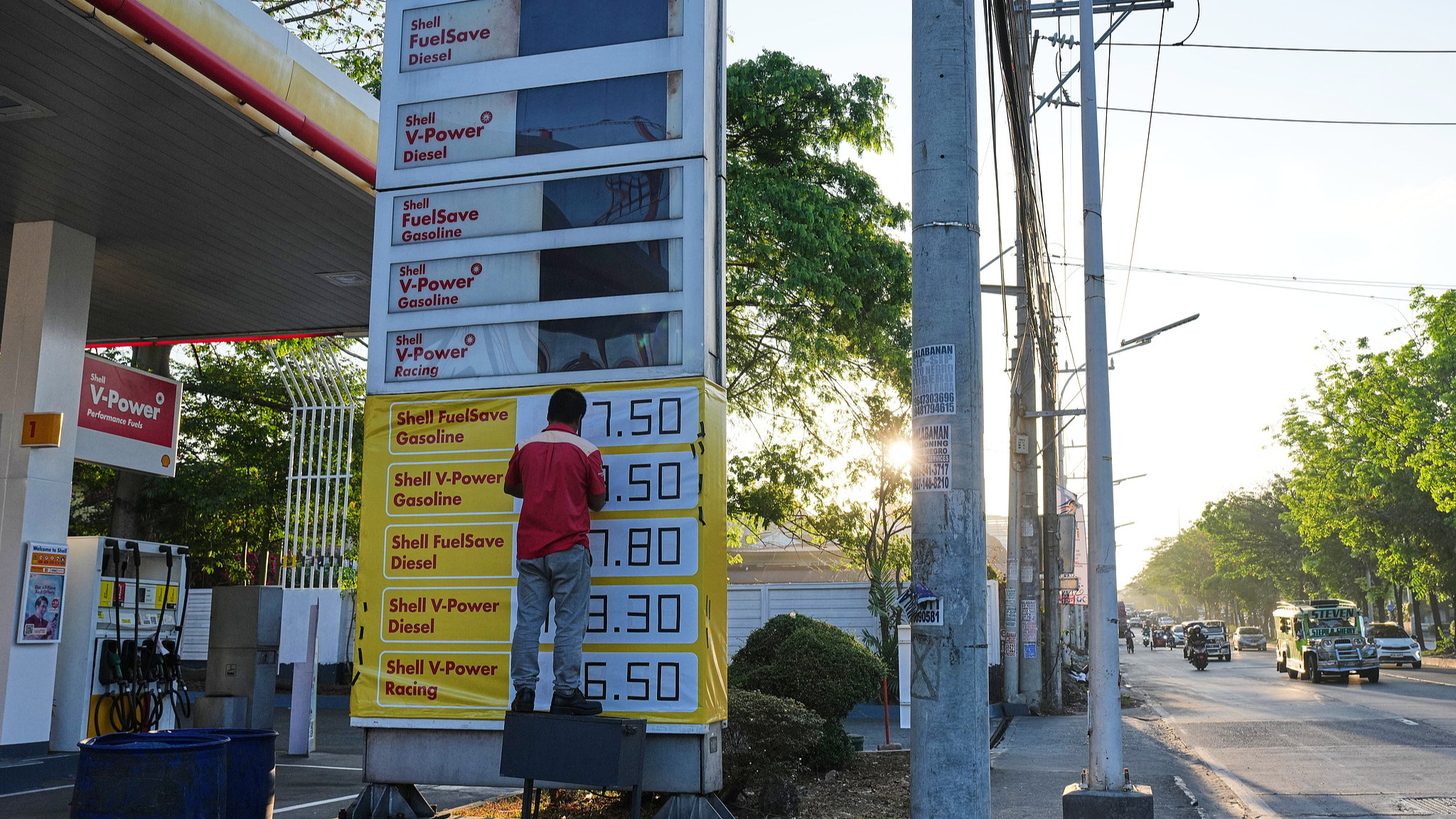 A worker manually adjusts gasoline prices at a gas station in Quezon City, the Philippines, March 24, 2026. /VCG