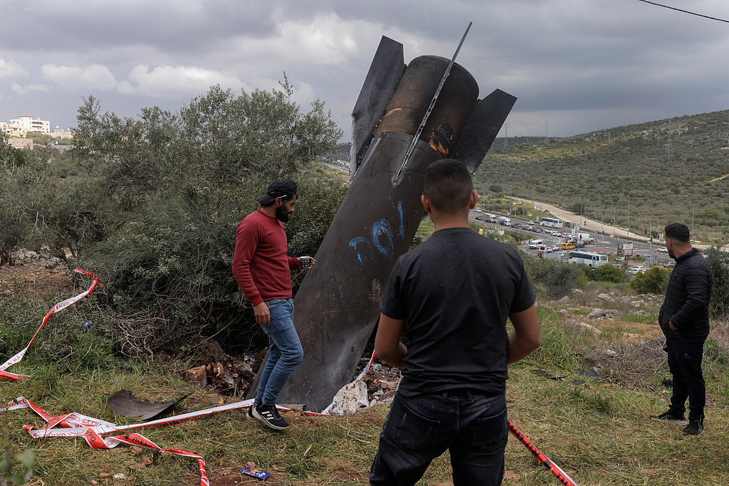 Iran launched overnight missile and drone attacks on the Israeli cities of Eilat, Dimona and Tel Aviv, as well as US bases in the Middle East. Palestinians inspect the wreckage of an Iranian missile in Kifl Haris, West Bank, on March 24, 2026. /VCG