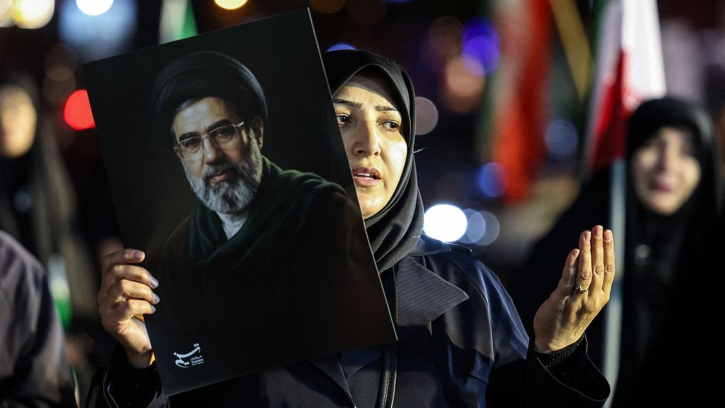 A woman holds a portrait of Iran's Supreme Leader Mojtaba Khamenei as people march in support of the Iranian armed forces in central Tehran, Iran, March 25, 2026. /VCG