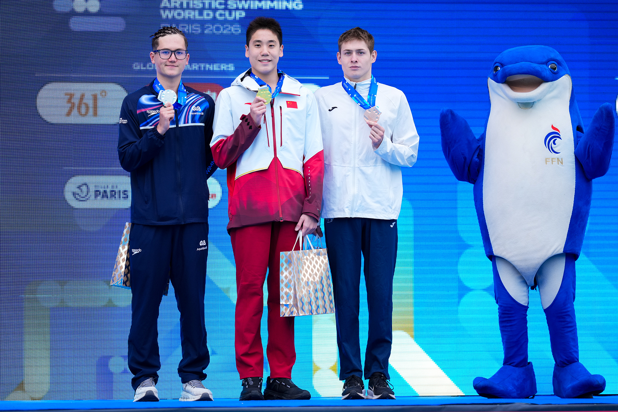 L-R: Silver medalist Ranjuo Tomblin of Great Britain, gold medalist Guo Muye of China and bronze medalist Viktor Druzin of Kazakhstan display their awards after the men's solo technical final at the Artistic Swimming World Cup in Paris, France, March 27, 2026. /VCG