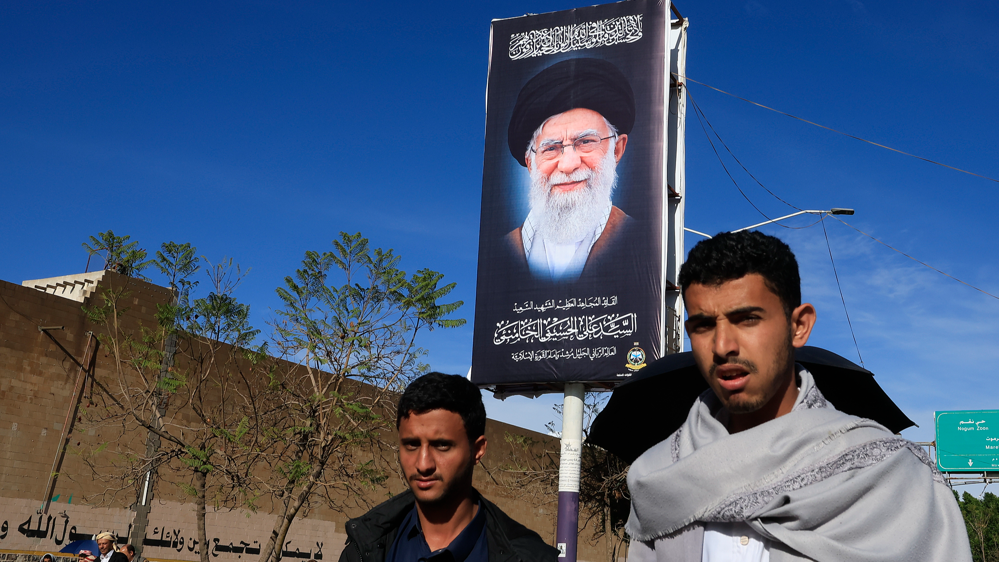 Houthi supporters walk past a billboard featuring late Iranian Supreme Leader Ayatollah Ali Khamenei on a street amid regional tensions in Sanaa, Yemen, March 27, 2026. /VCG