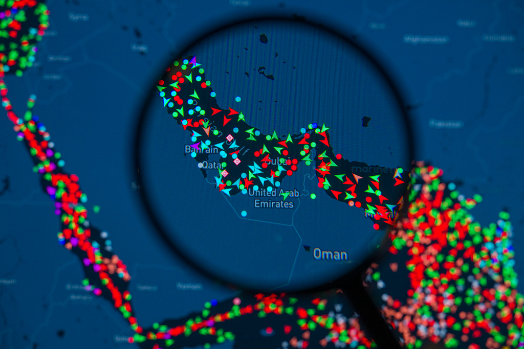 A MarineTraffic map showing ship movements in the Strait of Hormuz is pictured through a magnifying glass in this photo illustration taken in Brussels, Belgium, March 15, 2026. /CFP