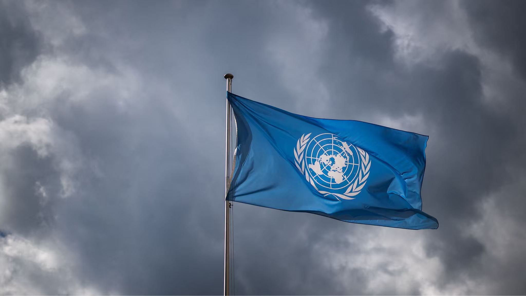 A file photo of the United Nations (UN) flag waves under a cloudy sky at the United Nations Offices in Geneva. /VCG