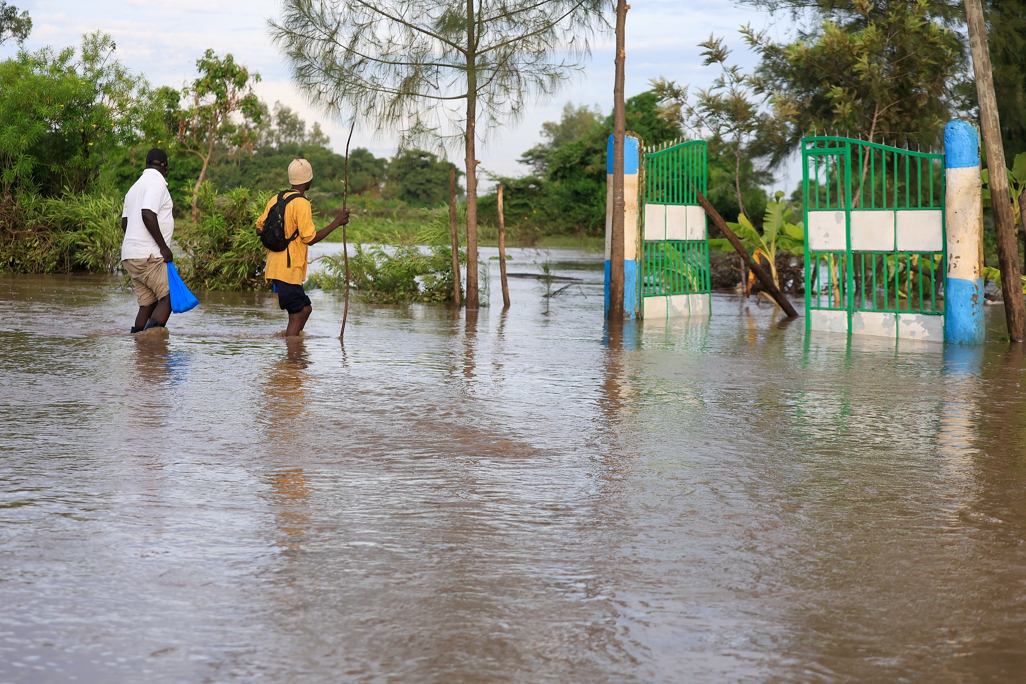 People walk through flood waters in Ahero, Kenya, March 24, 2026. /VCG
