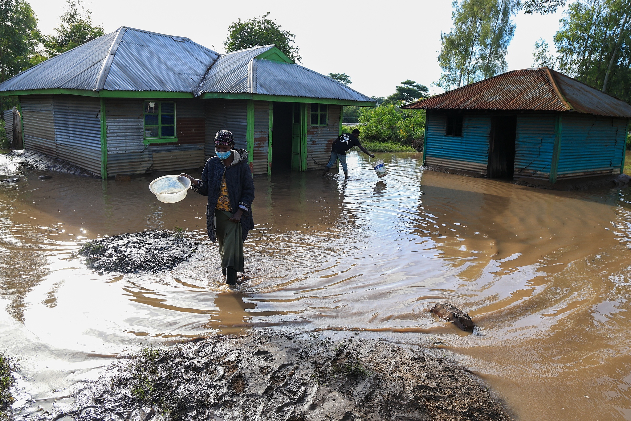 A woman walks through flood waters in Ahero, Kenya, March 24, 2026. /VCG