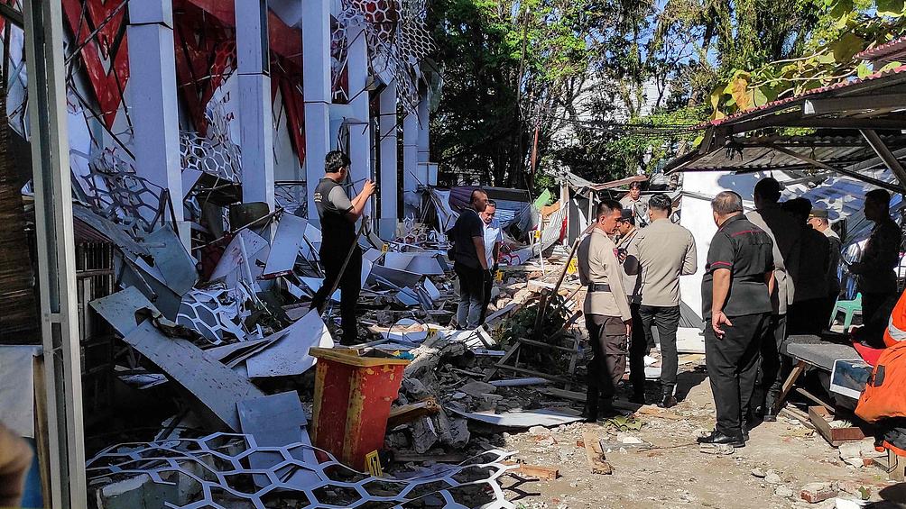 Police officers look at a building of the North Sumatra's National Sports Committee of Indonesia damaged following a severe offshore quake in Manado, North Sulawesi, April 2, 2026. /VCG