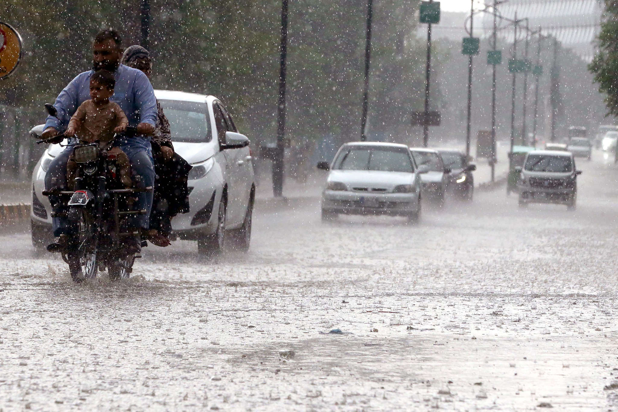 Commuters pass through a road during the heavy downpour in Peshawar, capital of Khyber Pakhtunkhwa province, Pakistan, March 30, 2026. /VCG