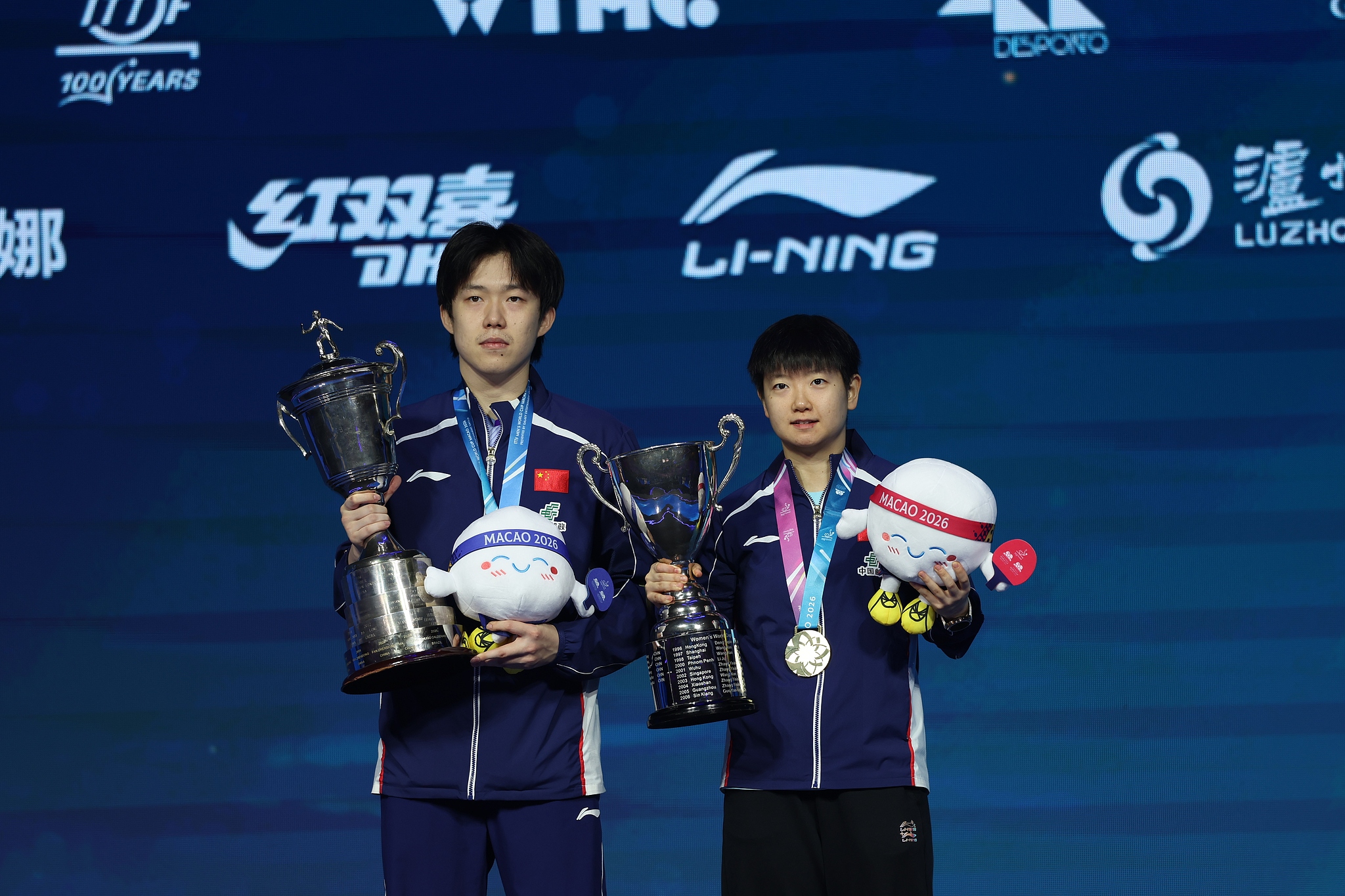China's Wang Chuqin (L) and Sun Yingsha display their respective men's and women's championship trophies during the awards ceremony at the ITTF Men's and Women's World Cup in China's Macao SAR (Special Administrative Region), April 5, 2026. /VCG