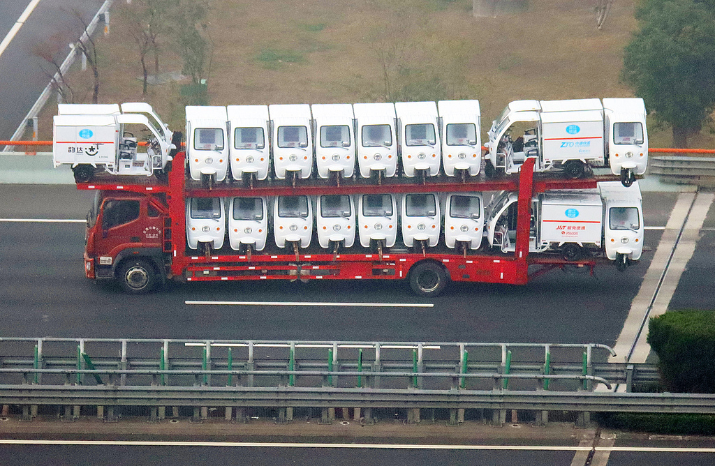Logistics trucks transport electric delivery vehicles in Changzhou City, Jiangsu Province, March 13, 2026./ VCG