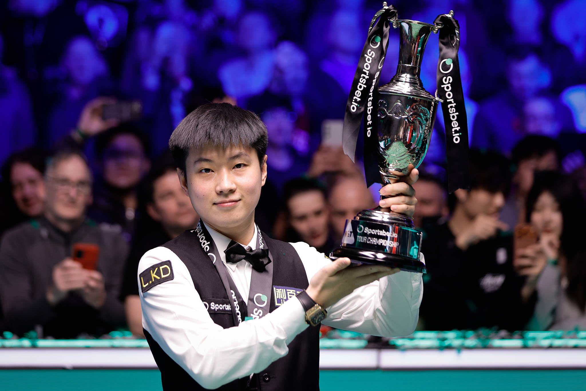 China's Zhao Xintong lifts the trophy after beating England's Judd Trump in the final to win the World Snooker Tour Championship title in Manchester, England, April 5, 2026. /VCG