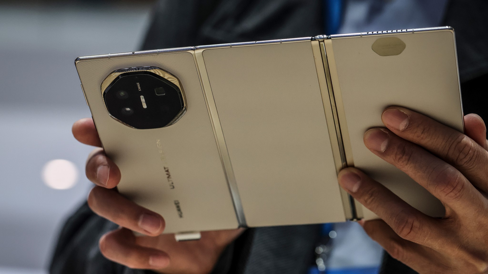 An attendee inspects a Huawei Mate XT tri-fold smartphone at MWC Barcelona 2026 in Barcelona, Spain, March 3, 2026. /VCG