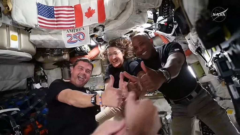 Artemis II crew members Reid Wiseman (L), Christina Koch (C) and Victor Glover give their thumbs up aboard the Orion spacecraft, April 6, 2026. /VCG