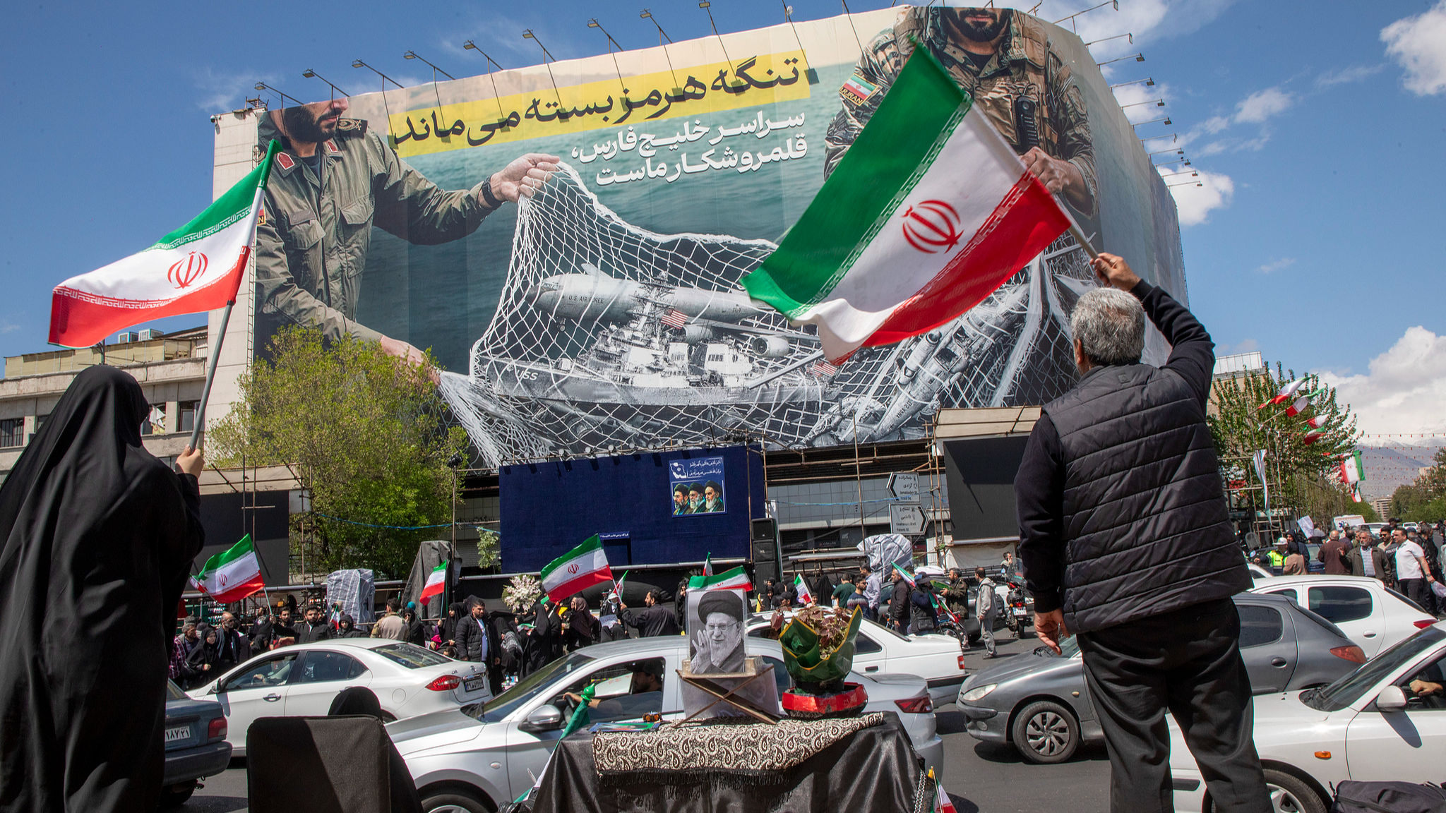 Iranians hold national flags as they gather in Tehran's Revolution Square after the United States and Iran agreed to a two-week ceasefire in Tehran, Iran, April 8, 2026. /VCG