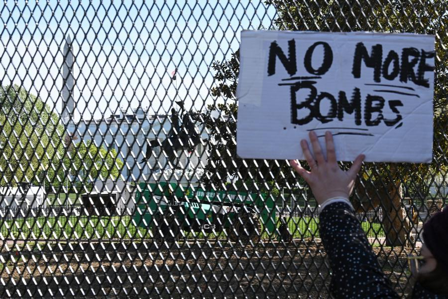A demonstrator holds a placard in front of the White House in the United States, April 7, 2026. /Xinhua