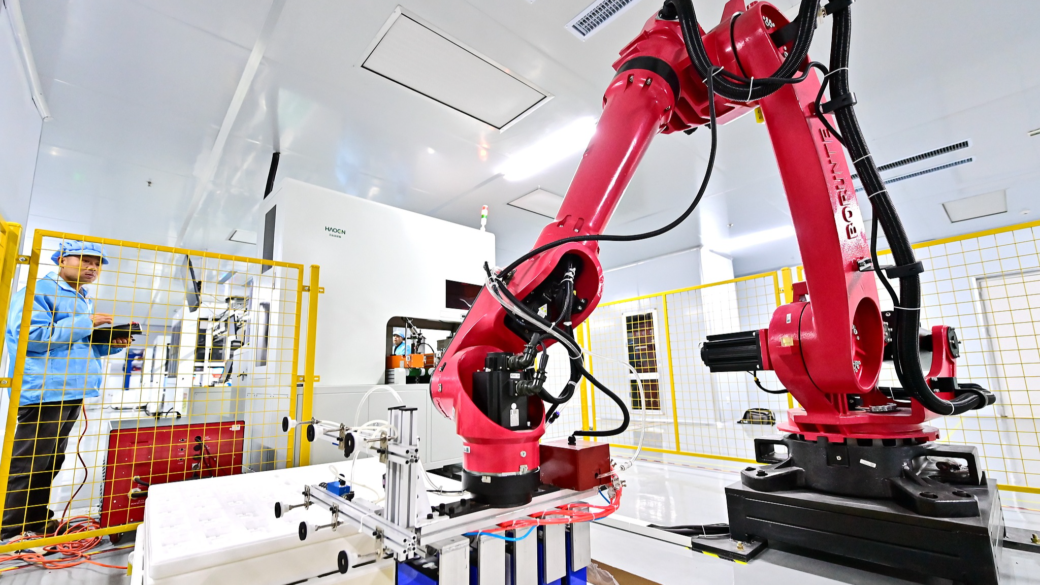 A worker operates intelligent robotic arms to process parts for new energy vehicles at a technology company in Shangrao, east China's Jiangxi Province, April 1, 2025. /VCG
