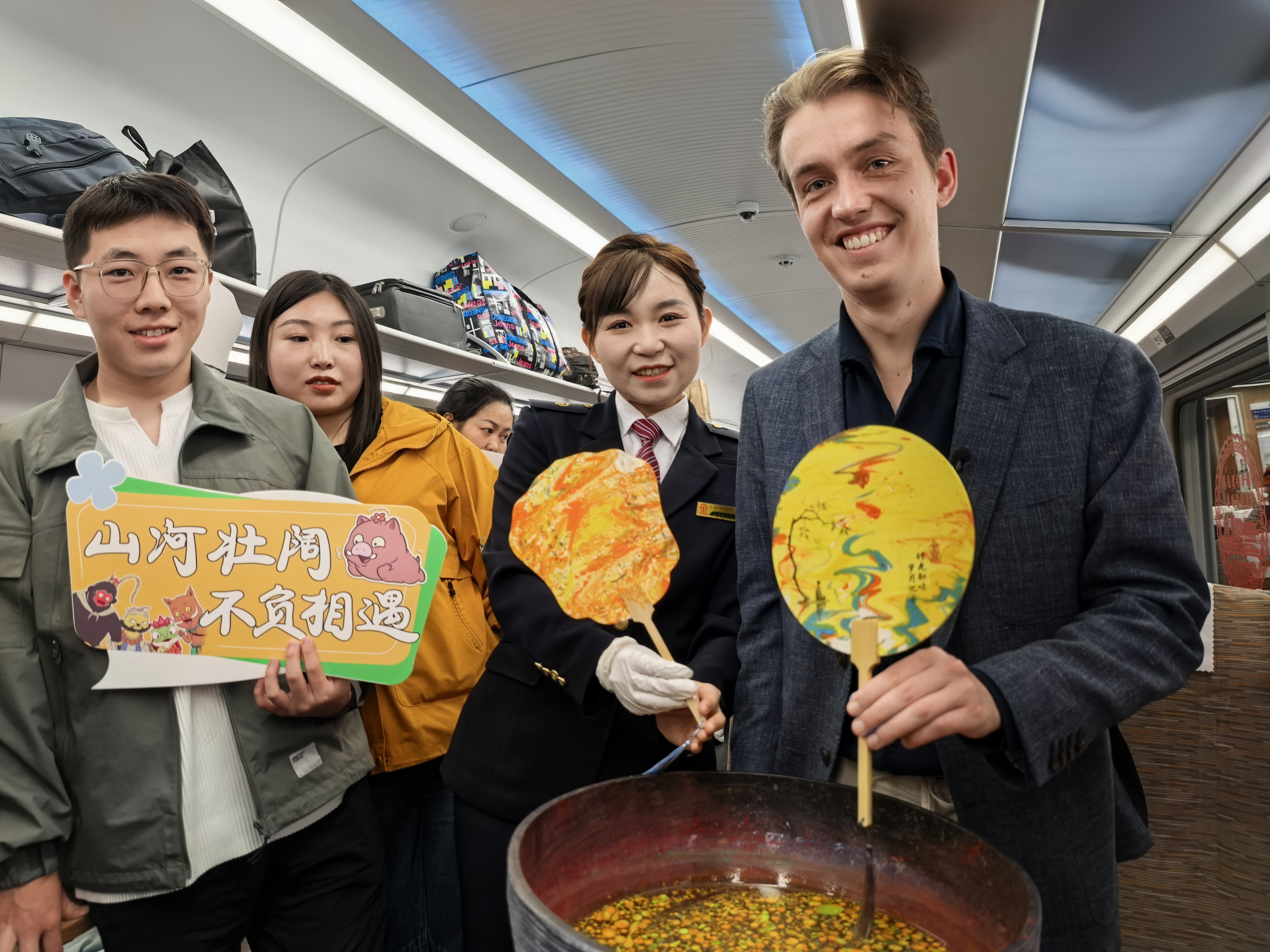 British traveler Rees Tyrrell (right) rides a movie-themed high-speed train inspired by the Chinese 2D animated film Nobody in this photo taken on April 10, 2026. /CGTN