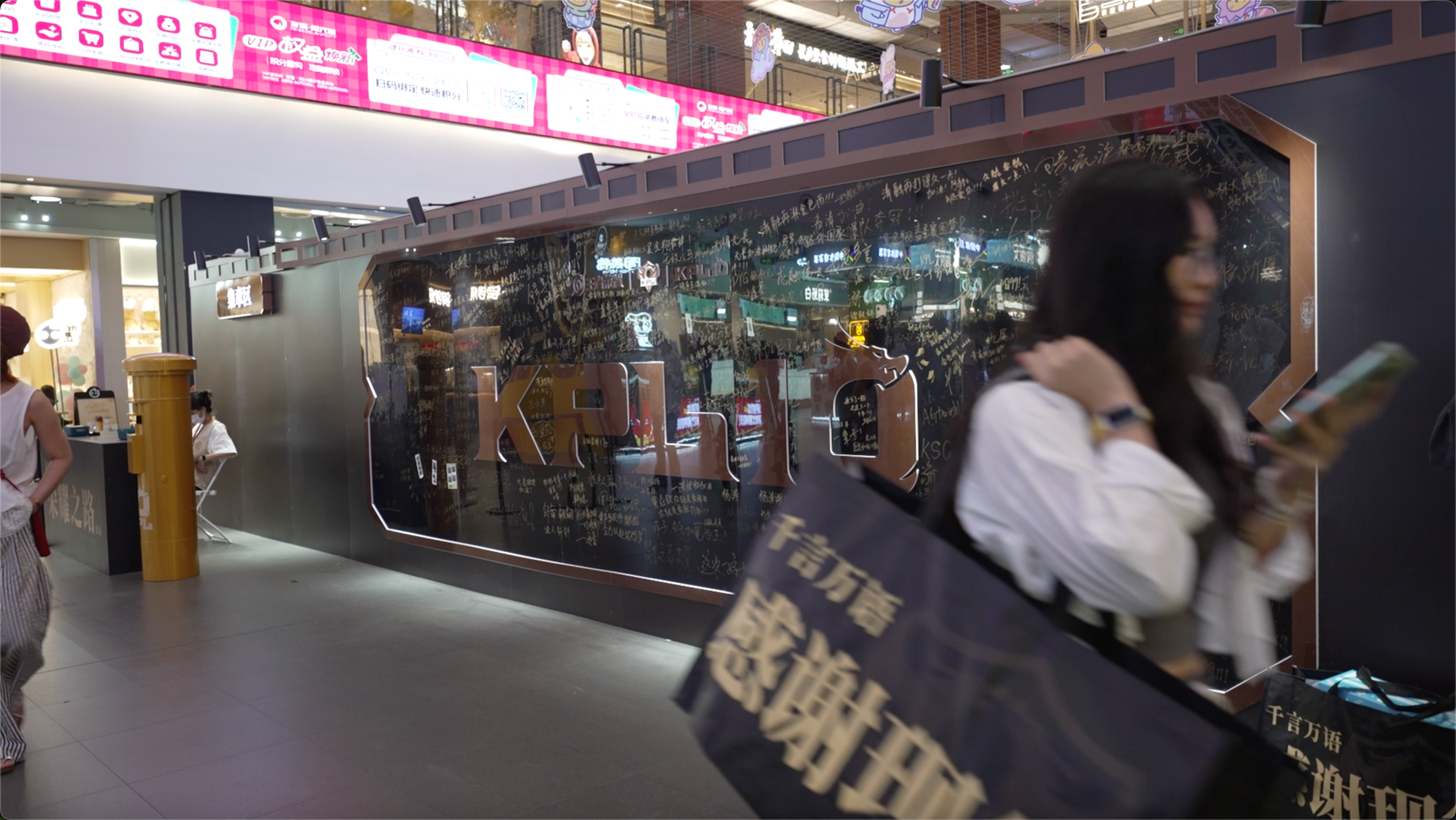 A customer walks past the KPL 10th Anniversary message wall outside the pop-up store at Haikou Friendship Sunshine City in Haikou, south China's Hainan Province, April 10, 2026. /CGTN