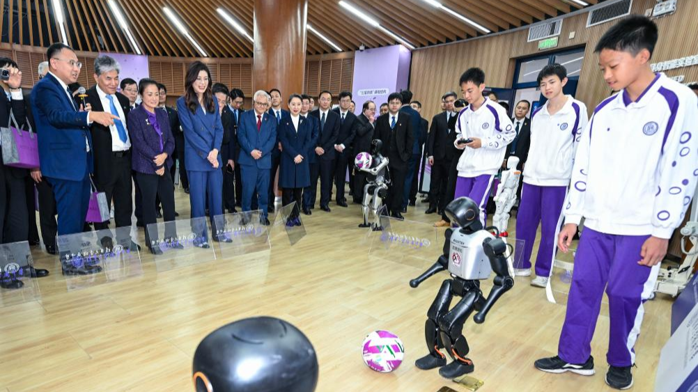 Cheng Li-wun, chairwoman of the Chinese Kuomintang (KMT) party, watches intelligent robots play football at a Tsinghua University High School laboratory in Beijing, capital of China, April 10, 2026. /Xinhua