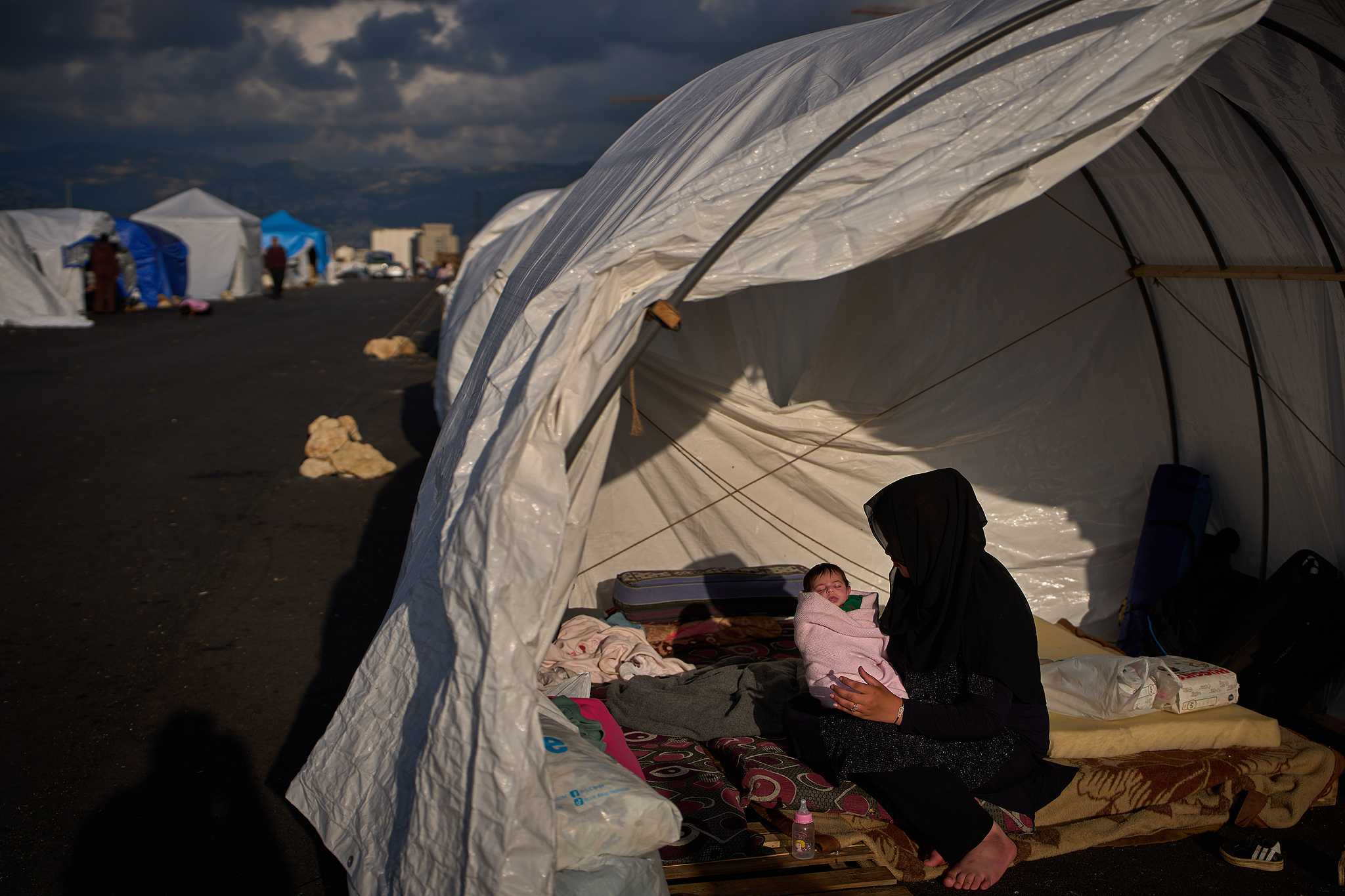 Haifa Kenjo, who fled Israeli air strikes on the southern suburbs of Beirut, holds her 15-day-old daughter Shiman inside the tent she uses as a shelter and where she gave birth to her in Beirut, April 12, 2026. /VCG