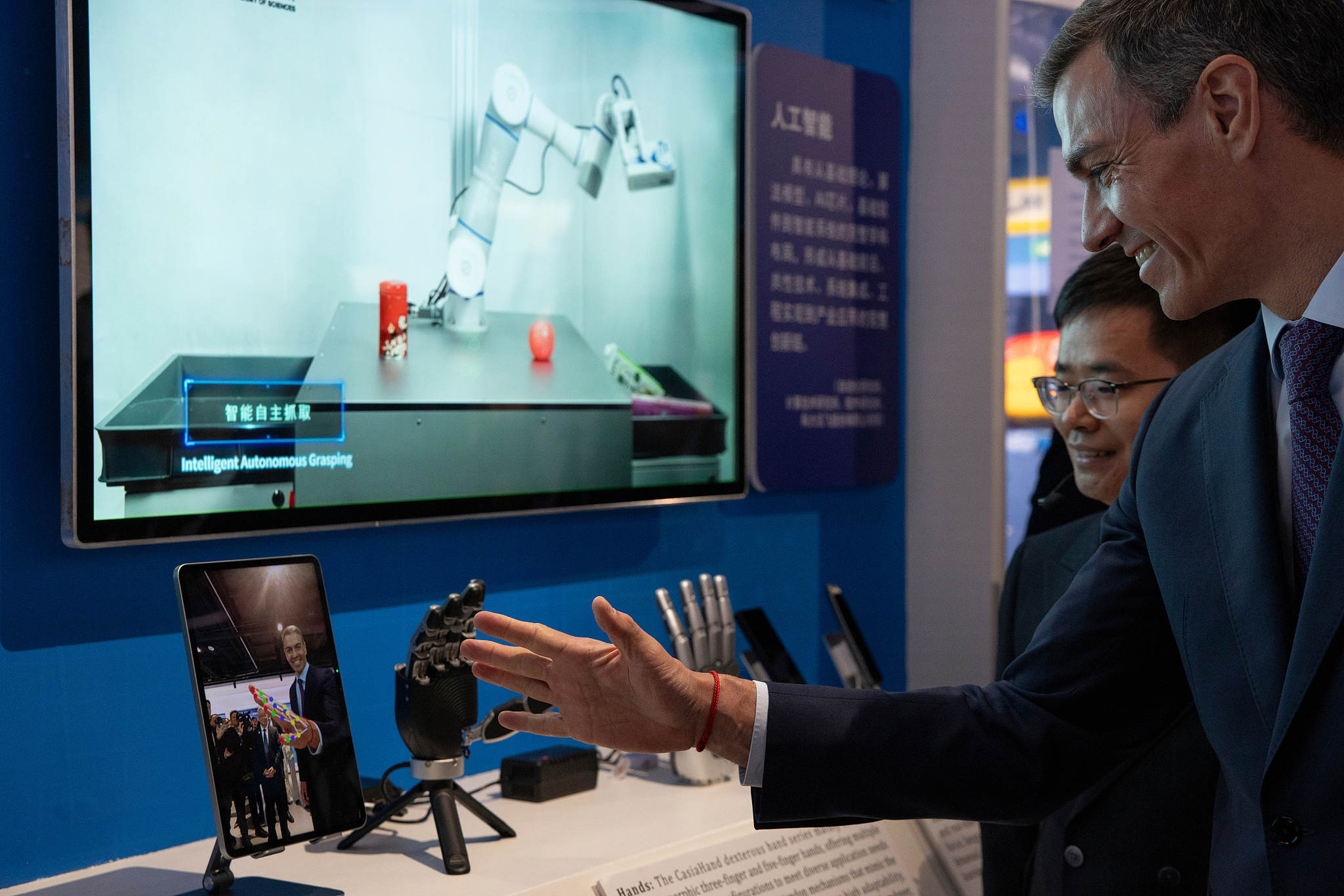 Spanish Prime Minister Pedro Sanchez checks a robotic hand during his visit to the University of Chinese Academy of Sciences in Beijing, April 13, 2026. /CFP