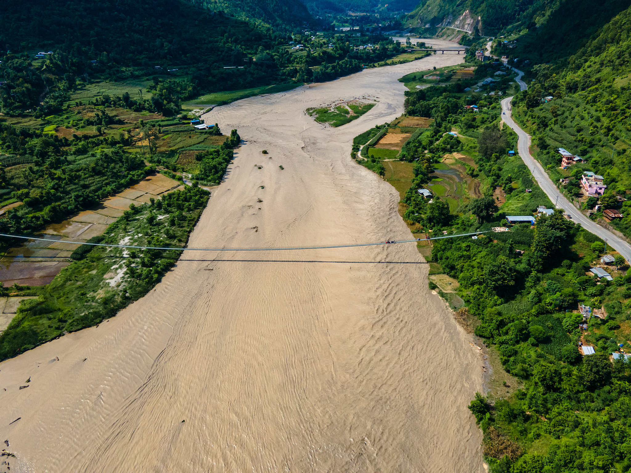 The aerial view shows the Trishuli River flood affecting the riverbanks and houses in Nuwakot, Nepal, July 8, 2025. /VCG