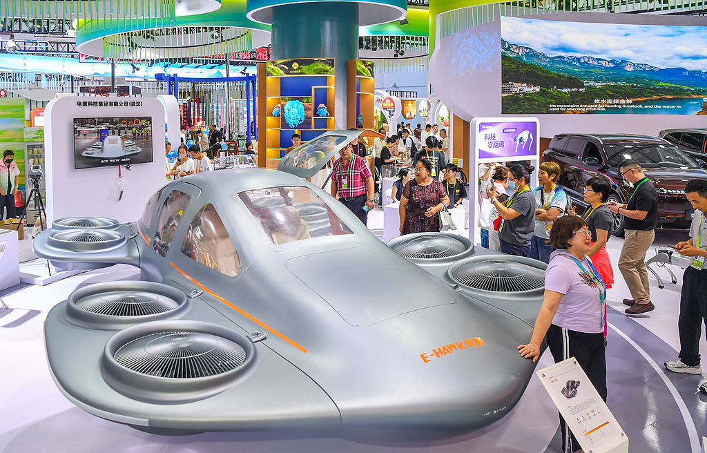 Visitors gather around and experience the futuristic EFC1200 “Flying Car” on display at the Hubei exhibition area on the opening day of the sixth China International Consumer Products Expo in Haikou, south China's Hainan Province, April 13, 2026. /CFP