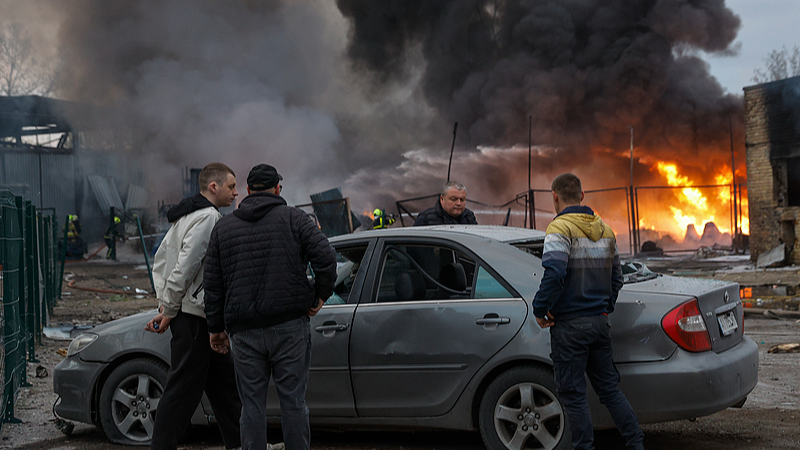 Locals are seen near a damaged car at the site of a Russian strike on a civilian storage facility in Kyiv, Ukraine, April 16, 2026. /VCG