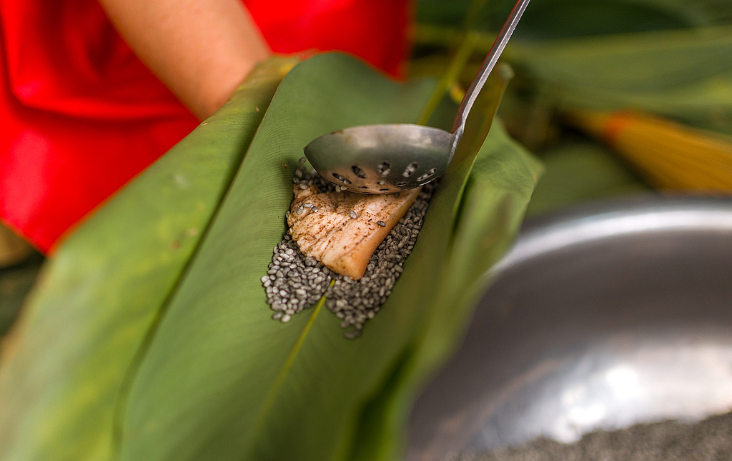People layer fillings into pillow-shaped zongba in Wangmo County, Guizhou Province on April 16, 2026. /VCG