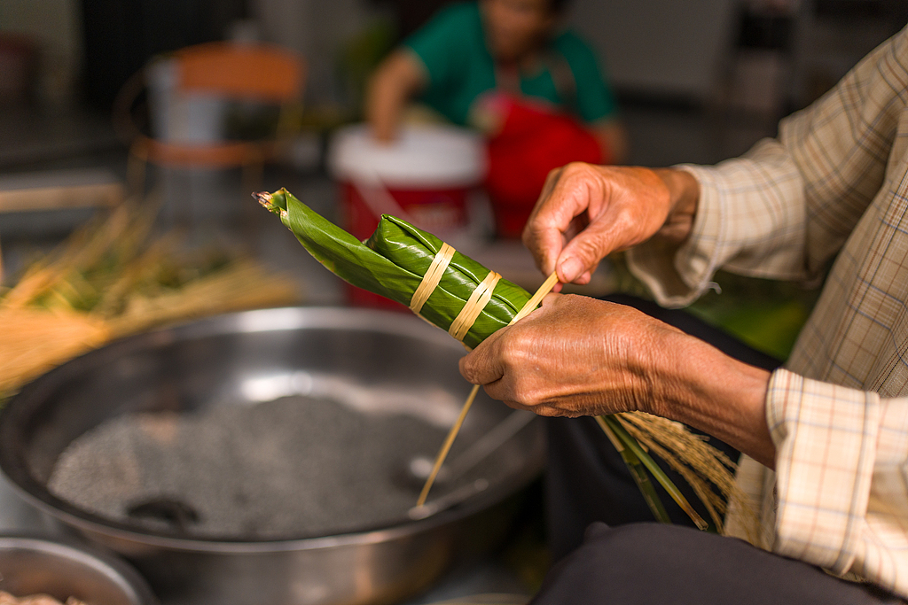 Village residents tie pillow-shaped zongba in Wangmo County, Guizhou Province on April 16, 2026. /VCG