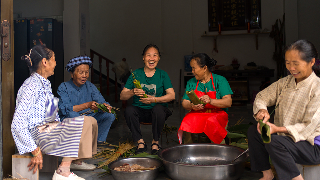 Villagers in Xintun Buyi Village gathered to make pillow-shaped zongba, in Wangmo County, Guizhou Province on April 16, 2026. /VCG