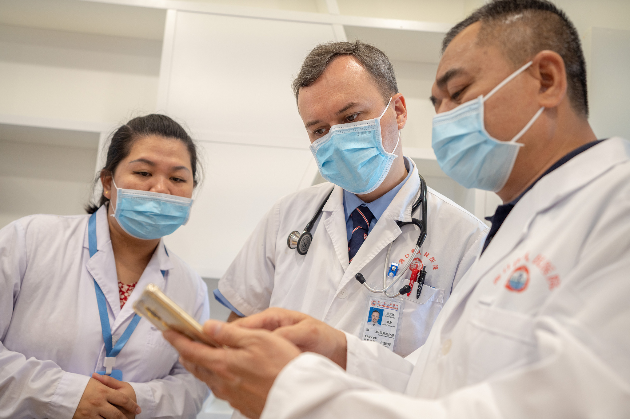 At the International Medical Clinic of Haikou People's Hospital, an American chief physician discusses a medical case with colleagues. /CFP