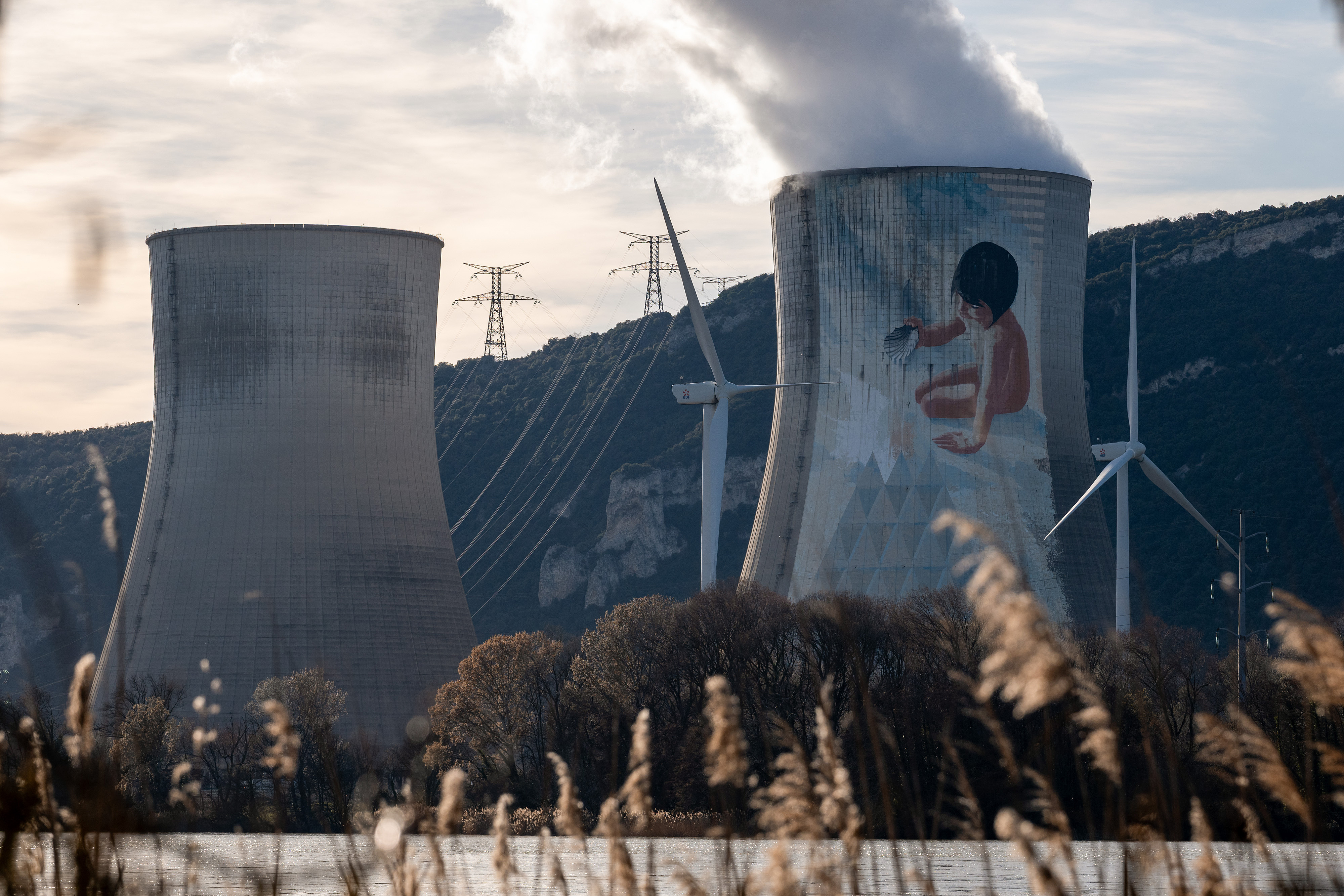 Power transmission lines and wind turbines near the Cruas Nuclear Power Station, operated by Electricite de France SA (EDF), near Montelimar, France, on Wednesday, February 25, 2026. /VCG
