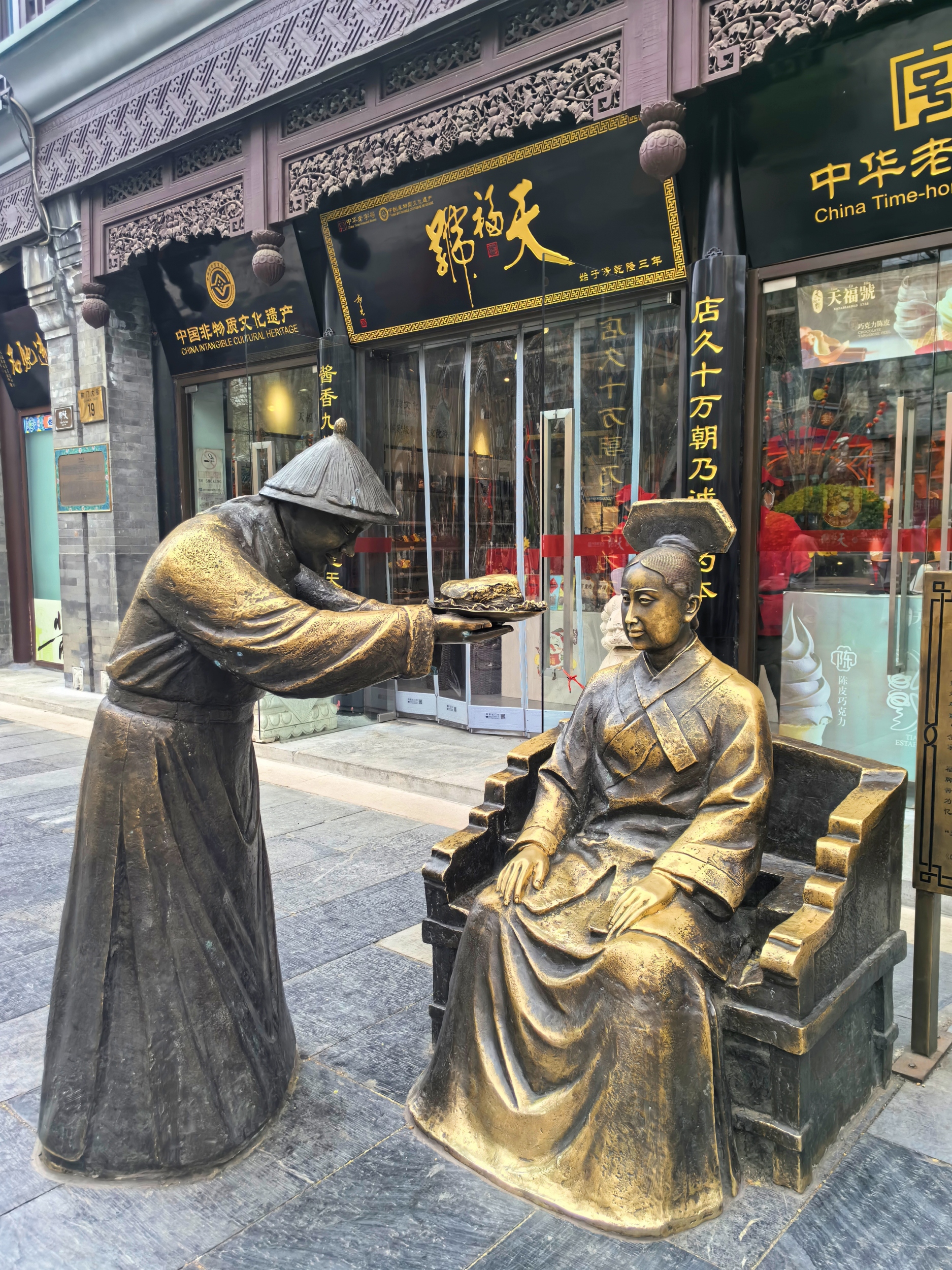Sculptures are seen in front of a China time-honored shop at Qianmen Street in Beijing on April 6, 2026. /CGTN
