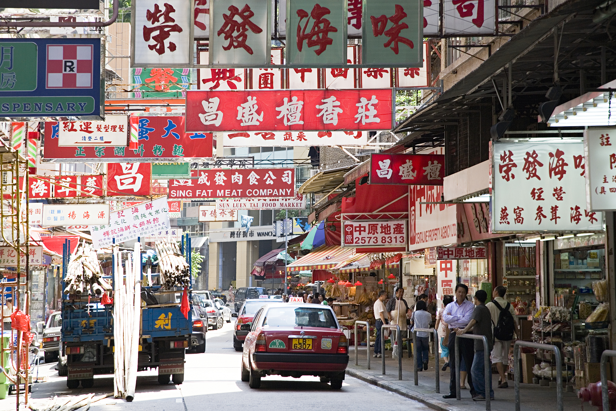 Iconic red taxis move through signage-filled streets in Wan Chai, HKSAR, China. /VCG