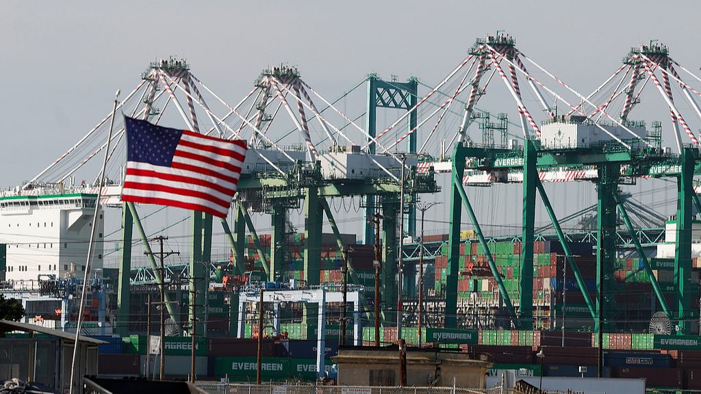 An American flag flutters in the wind in front of cranes at the Port of Los Angeles in Los Angeles, California, United States, March 4, 2026. /VCG