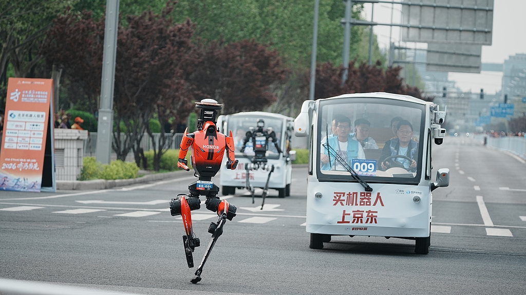 A robot from Honor sprints along the route of the Beijing Humanoid Robot Half-Marathon on April 19, 2026. Over 100 teams and more than 300 robots participated. /VCG