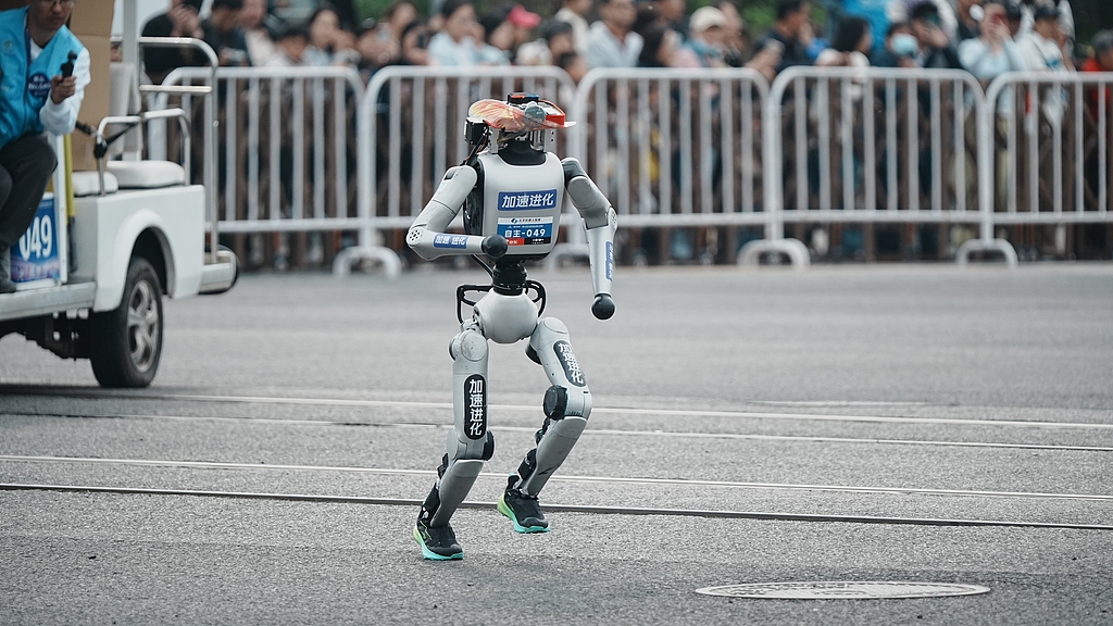 A robot sprints along the route of the Beijing Humanoid Robot Half-Marathon on April 19, 2026. Over 100 teams and more than 300 robots participated./VCG
