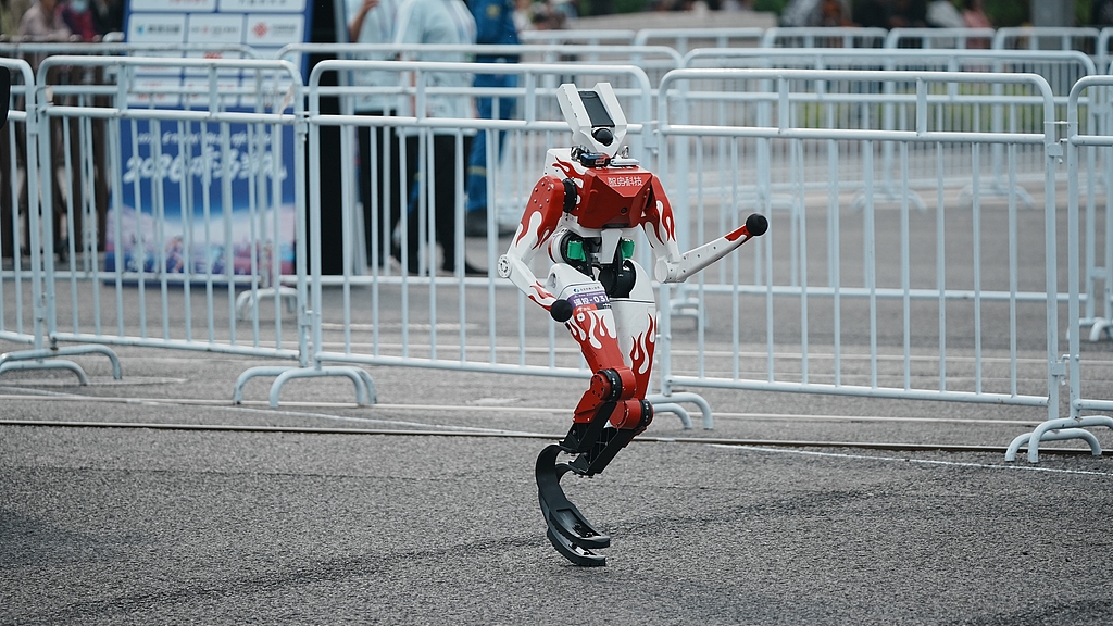 A robot sprints along the route of the Beijing Humanoid Robot Half-Marathon on April 19, 2026. Over 100 teams and more than 300 robots participated. /VCG