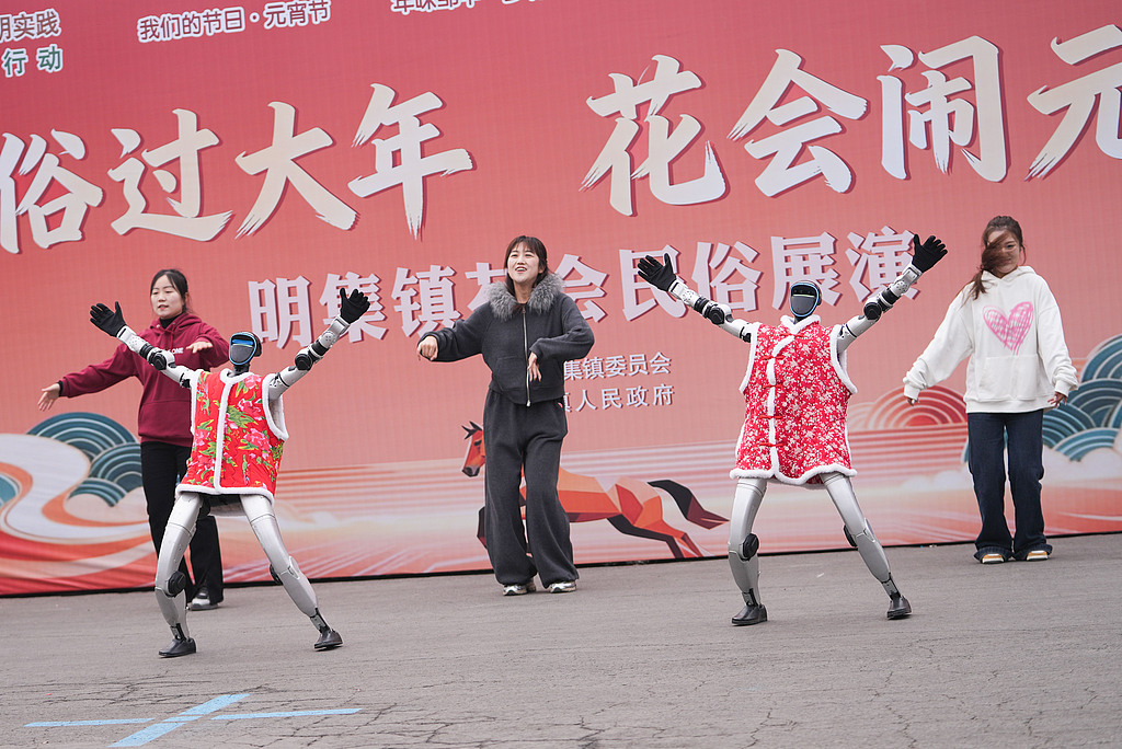 Robots in traditional costumes dance alongside humans on February 28, 2026, in Shandong Province, during the Lantern Festival. /VCG