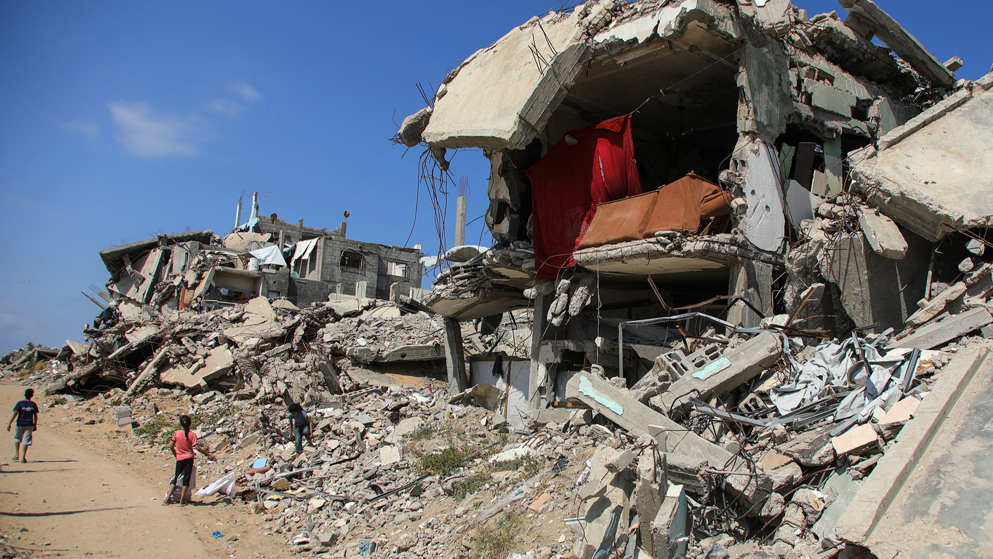 People walk past destroyed homes in Gaza City, Gaza, April 20, 2026. /VCG
