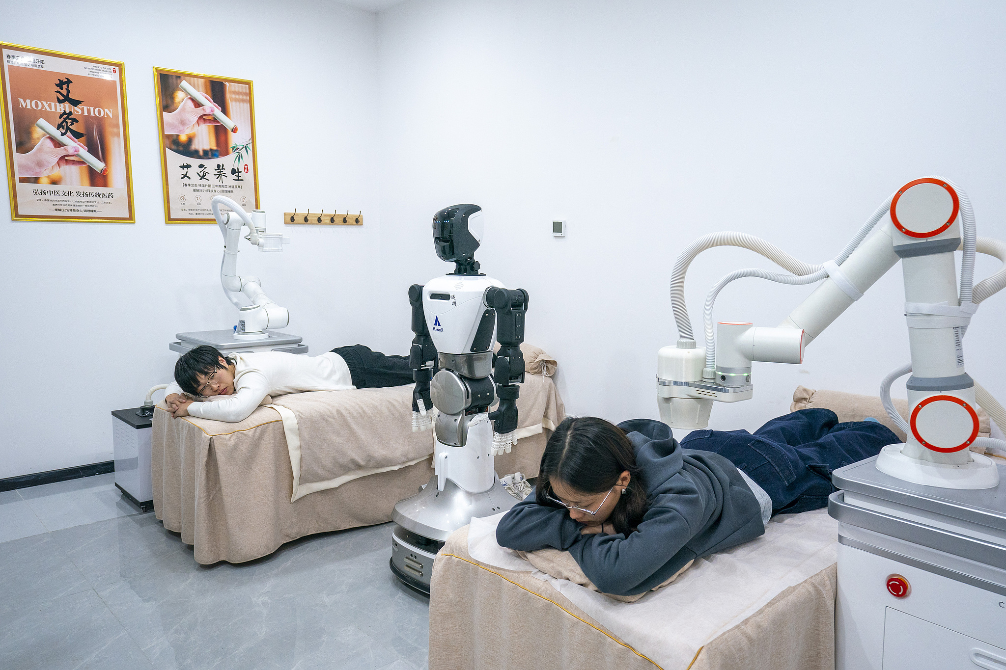 Customers experience robotic moxibustion therapy in Wuhan City, Hubei Province, on April 3, 2026. /VCG