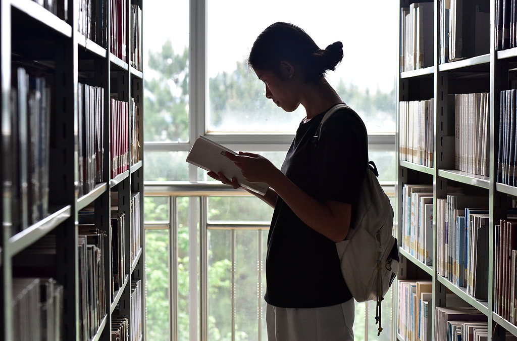 A college student reads a book at the library of Hezhou University in Guangxi Zhuang Autonomous Region, April 23, 2026. /VCG