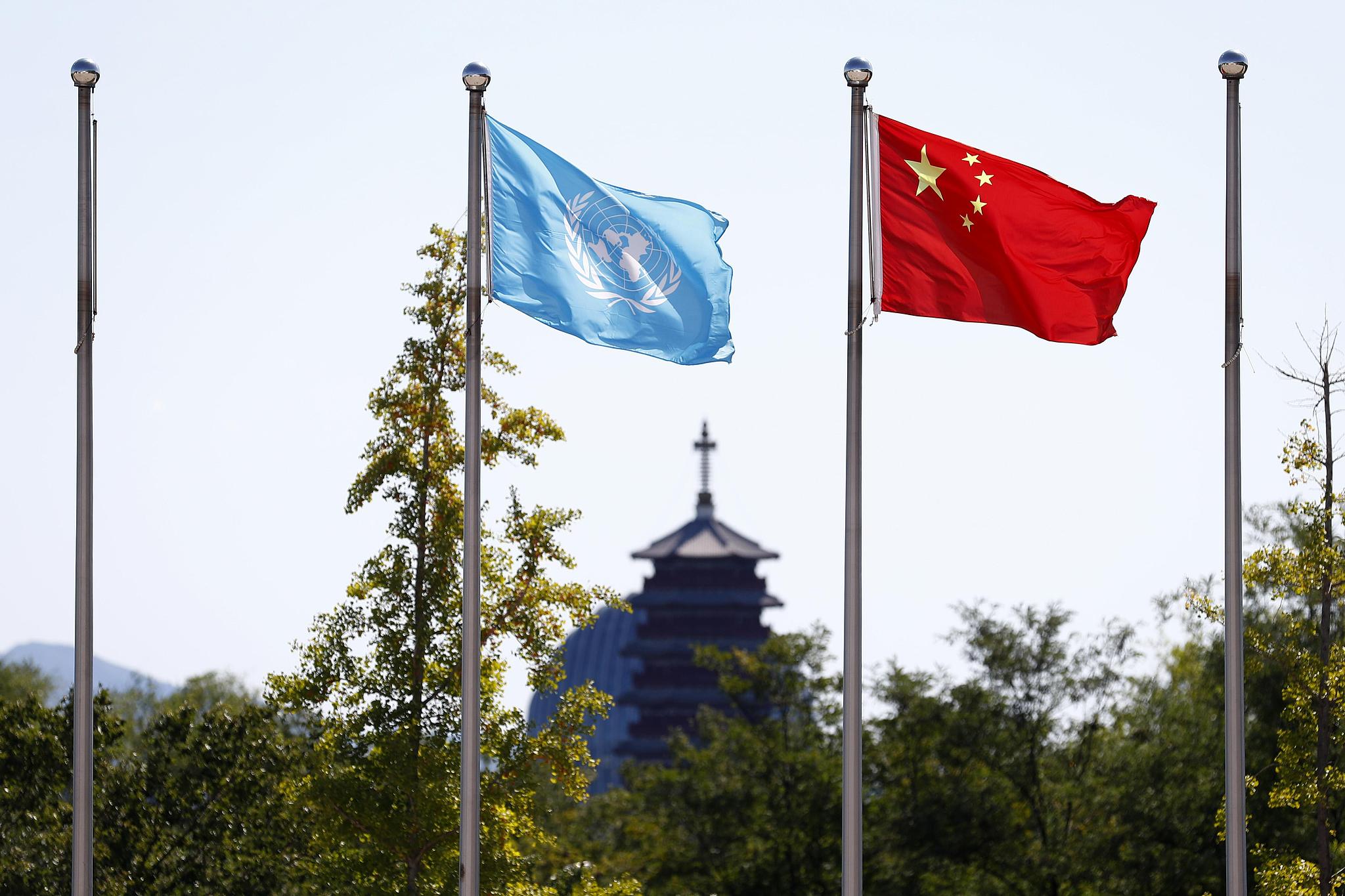 The national flag of the People's Republic of China (R) and the flag of the United Nations. /CFP