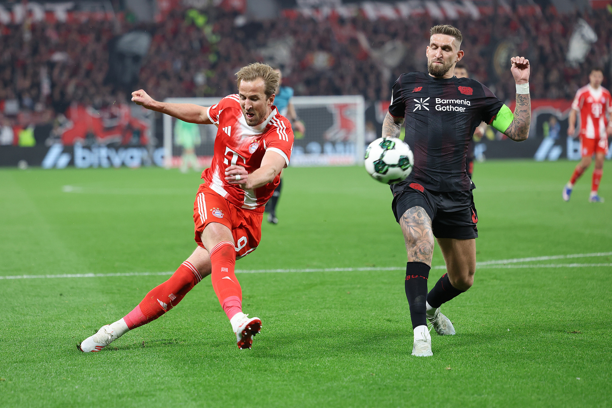 Bayern Munich's Harry Kane (L) scores a goal against Bayer Leverkusen in a DFB-Pokal semifinal match at the BayArena in Leverkusen, Germany, April 22, 2026. /VCG
