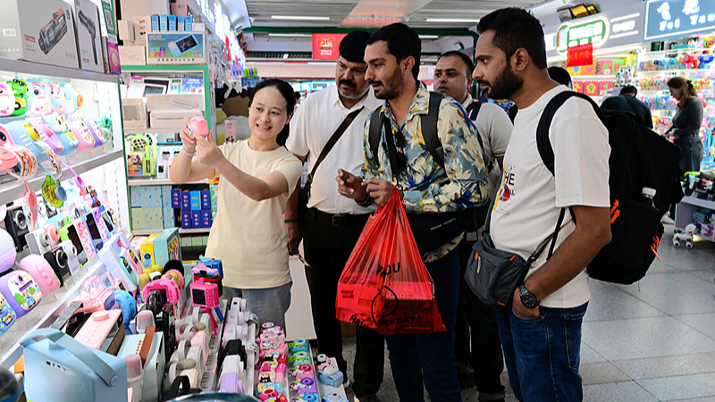 Businessmen discuss deals on children's toy cameras at the Yiwu International Trade City in Yiwu, east China's Zhejiang Province, April 22, 2026. /VCG