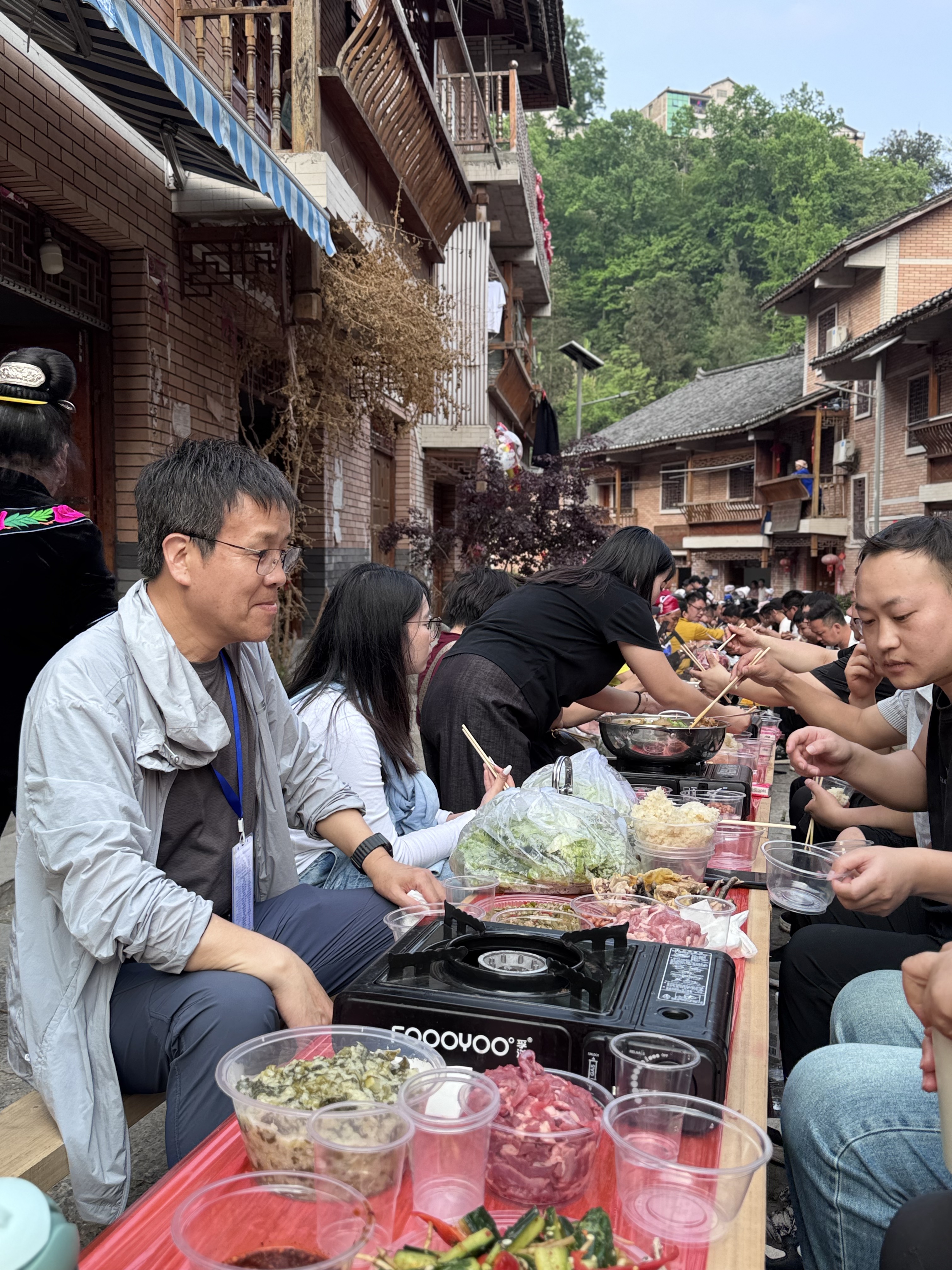 Locals and visitors gather together for a long-table feast, tasting Dong delicacies and homemade rice wine. /CGTN