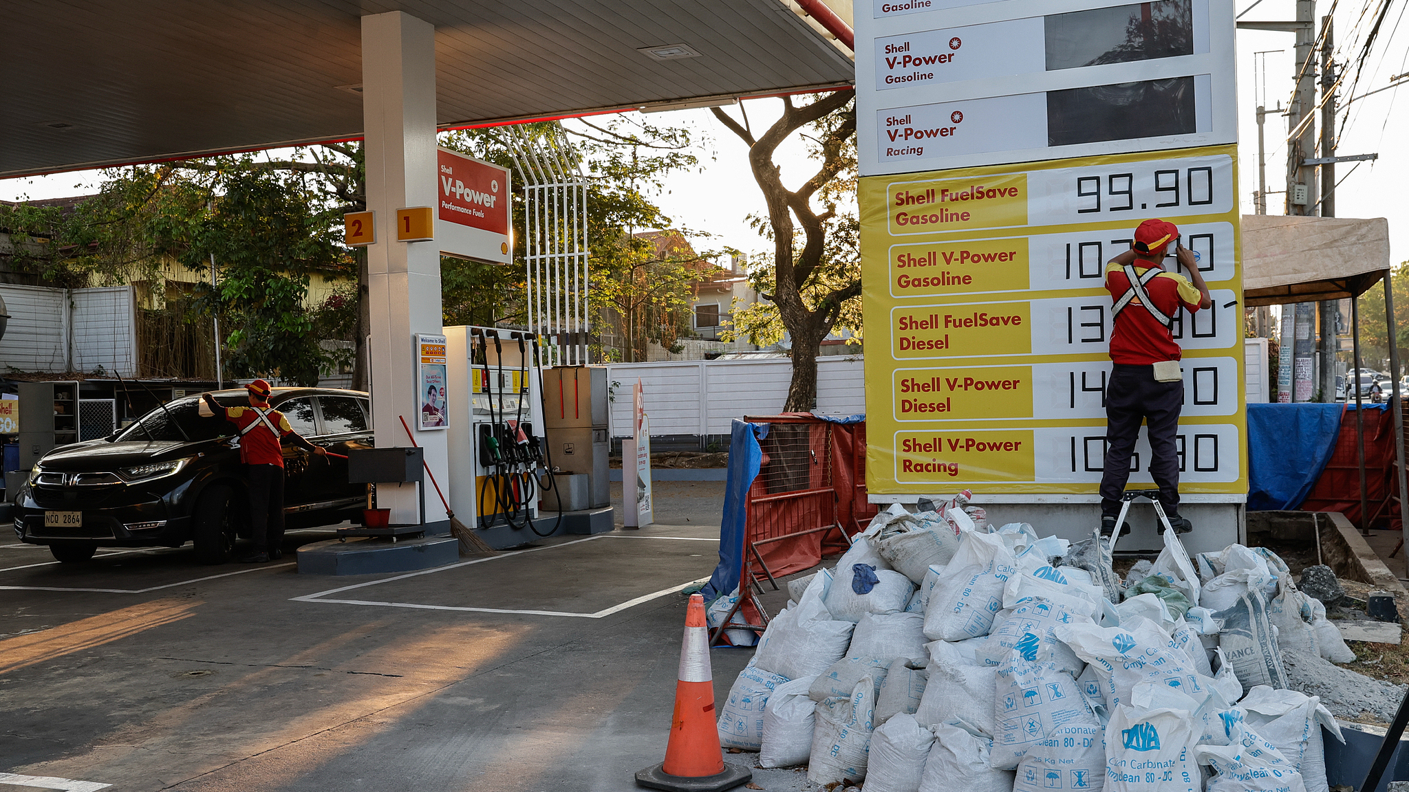 A worker uses adhesive tape to change fuel price figures at a fuel station in Quezon City, Metro Manila, Philippines, April 7, 2026. /VCG
