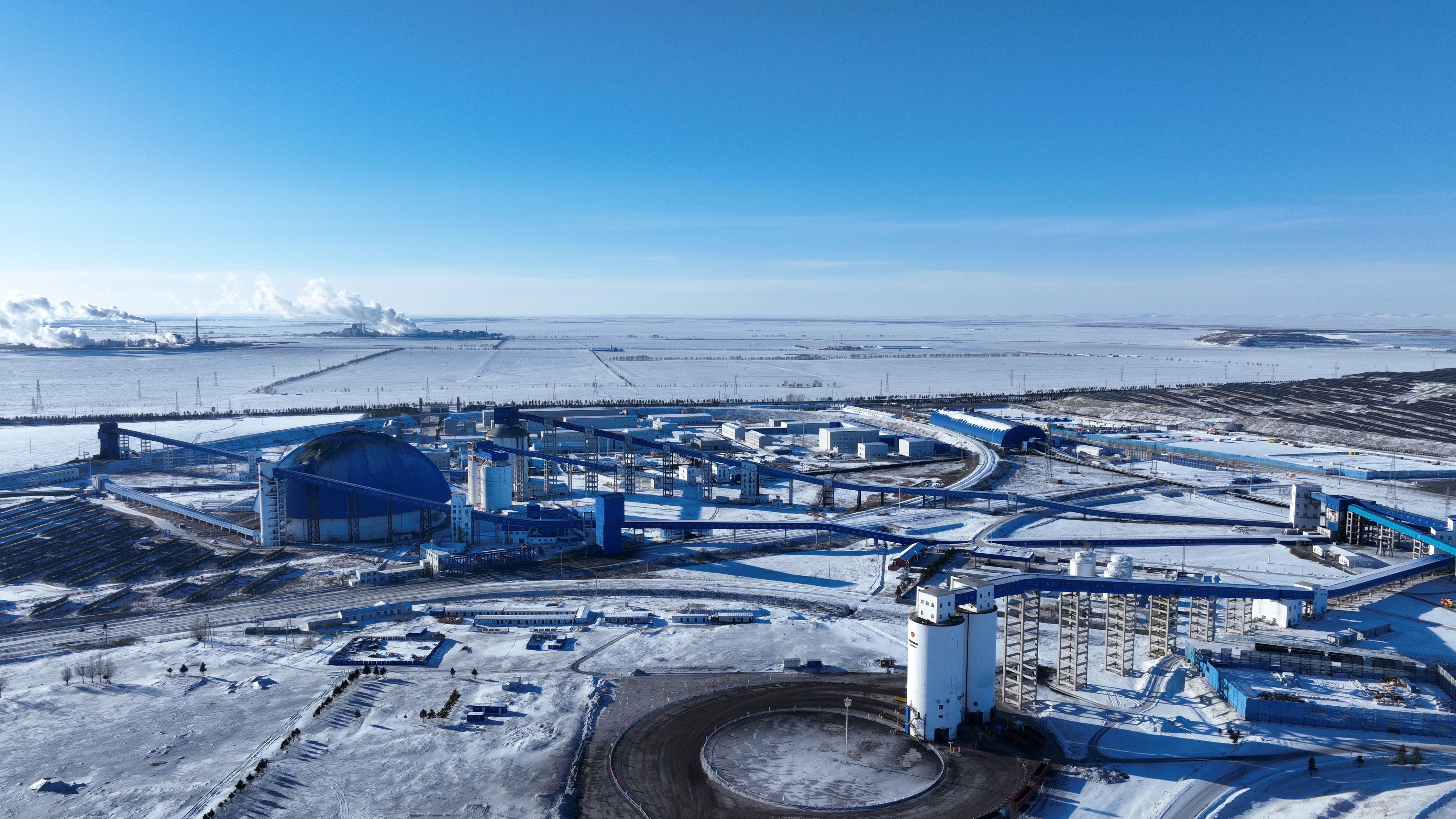 A modern coal mine production base seen under the snow, showing a closed coal supply, storage and transmission system, in Inner Mongolia, China, January 7, 2026. /VCG