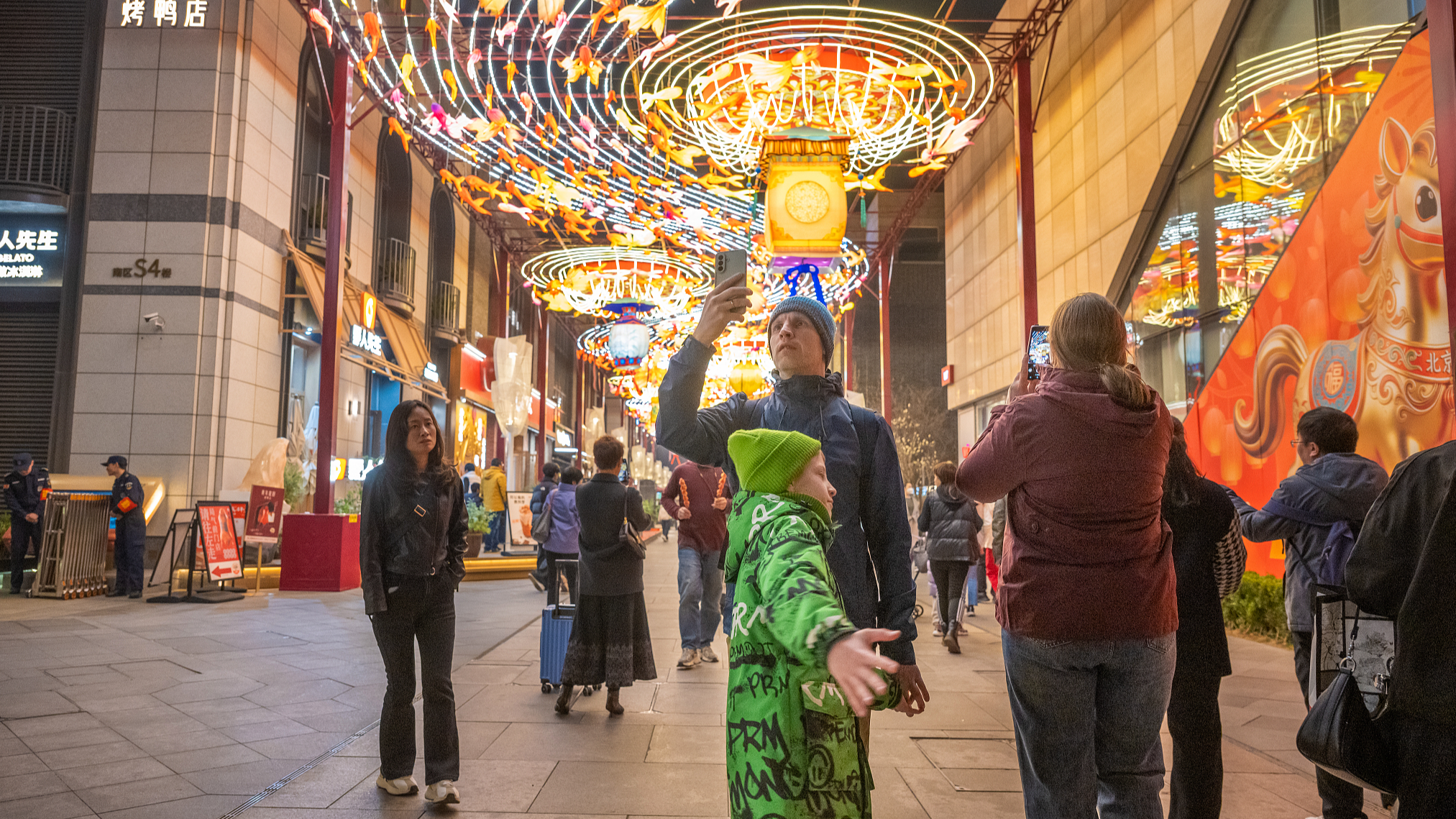 Foreign tourists walk along Qianmen Street, Beijing, China, March 21, 2026. /CFP